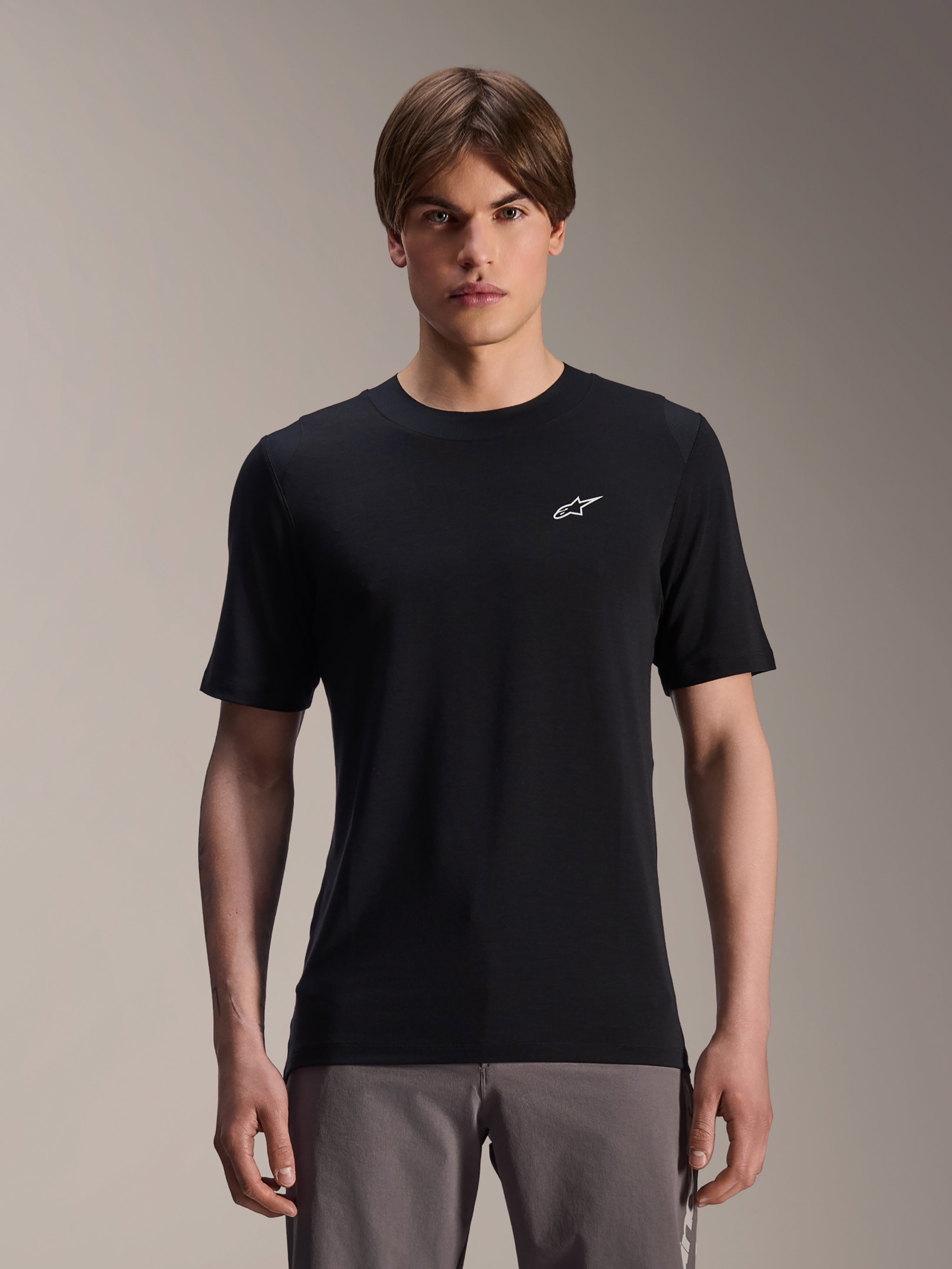 Alpinestars A-Dura Dri Wool Short Sleeve Jersey, maglia da ciclismo a maniche corte, nero, indossata da un modello, piccolo logo Alpinestars bianco sul petto, abbigliamento tecnico per trail MTB in tessuto di lana drirelease® traspirante