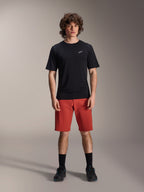 Alpinestars A-Dura Elite Shorts, pantaloncini MTB in Dark Orange, indossati con maglia nera a maniche corte e scarpe da ciclismo, abbigliamento tecnico per mountain bike