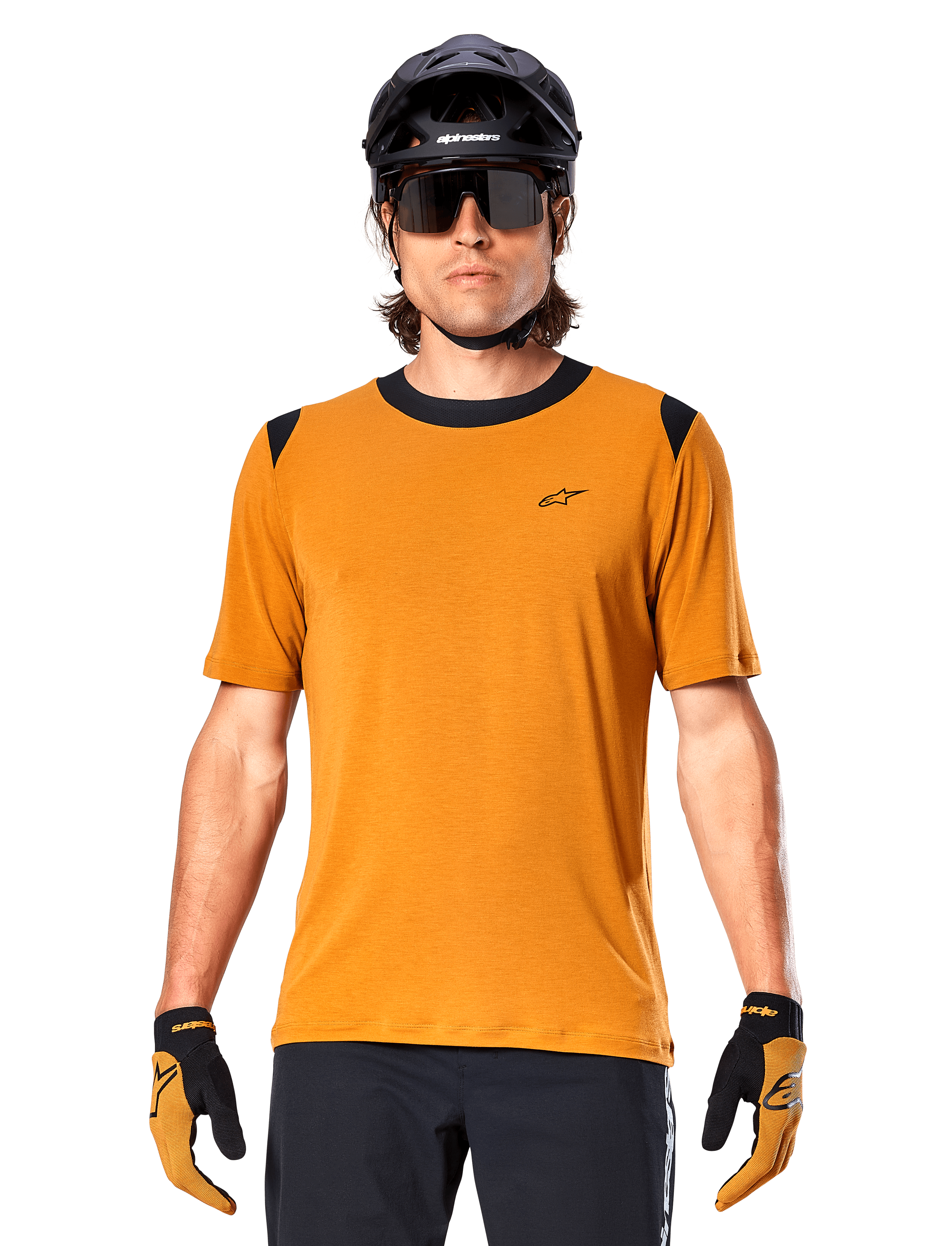 Maglia a maniche corte Alpinestars A-Dura Dri Wool, Oro Scuro, indossata con casco MTB nero, occhiali da sole e guanti, con colletto e pannelli sulle spalle neri, in misto lana traspirante drirelease per mountain bike