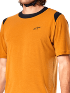 Maglia Alpinestars A-Dura Dri Wool, maglia da ciclismo a maniche corte, oro scuro, colletto e pannelli sulle spalle in rete nera, piccolo logo nero sul petto, vista frontale ravvicinata