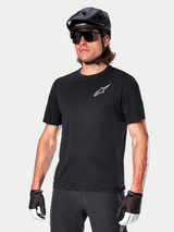 Alpinestars A-Aria Astar Short Sleeve Jersey in nero, indossata da un ciclista con casco MTB nero e occhiali da sole, con logo Astar bianco sul petto, abbigliamento tecnico leggero e traspirante per trail riding
