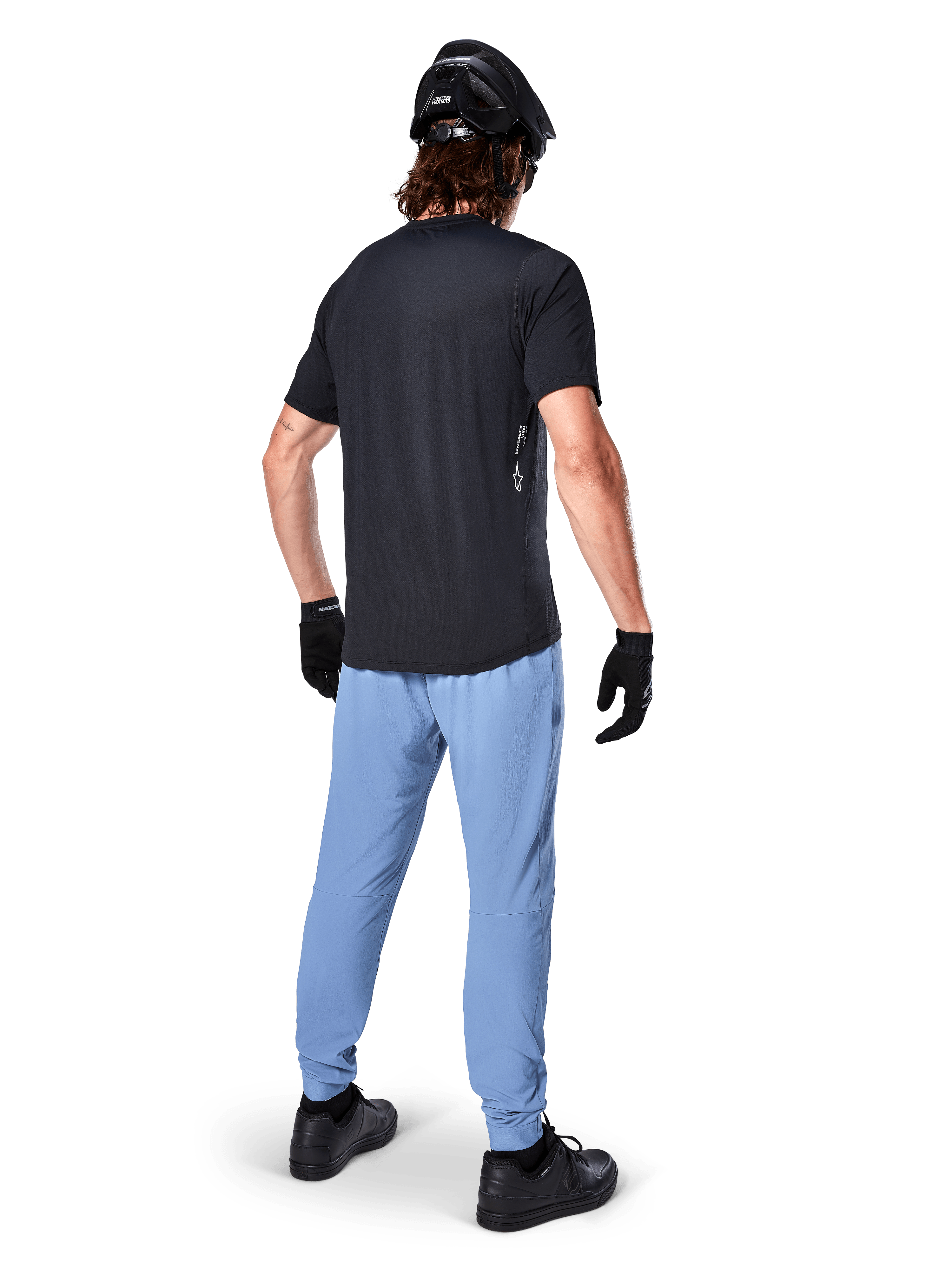 Alpinestars Maglia A-Dura Oscar - Maniche Corte, Nero, vista posteriore di un rider che indossa una maglia da mountain bike nera, abbinata a pantaloni azzurri, casco nero e guanti neri, abbigliamento tecnico da MTB per prestazioni off-road