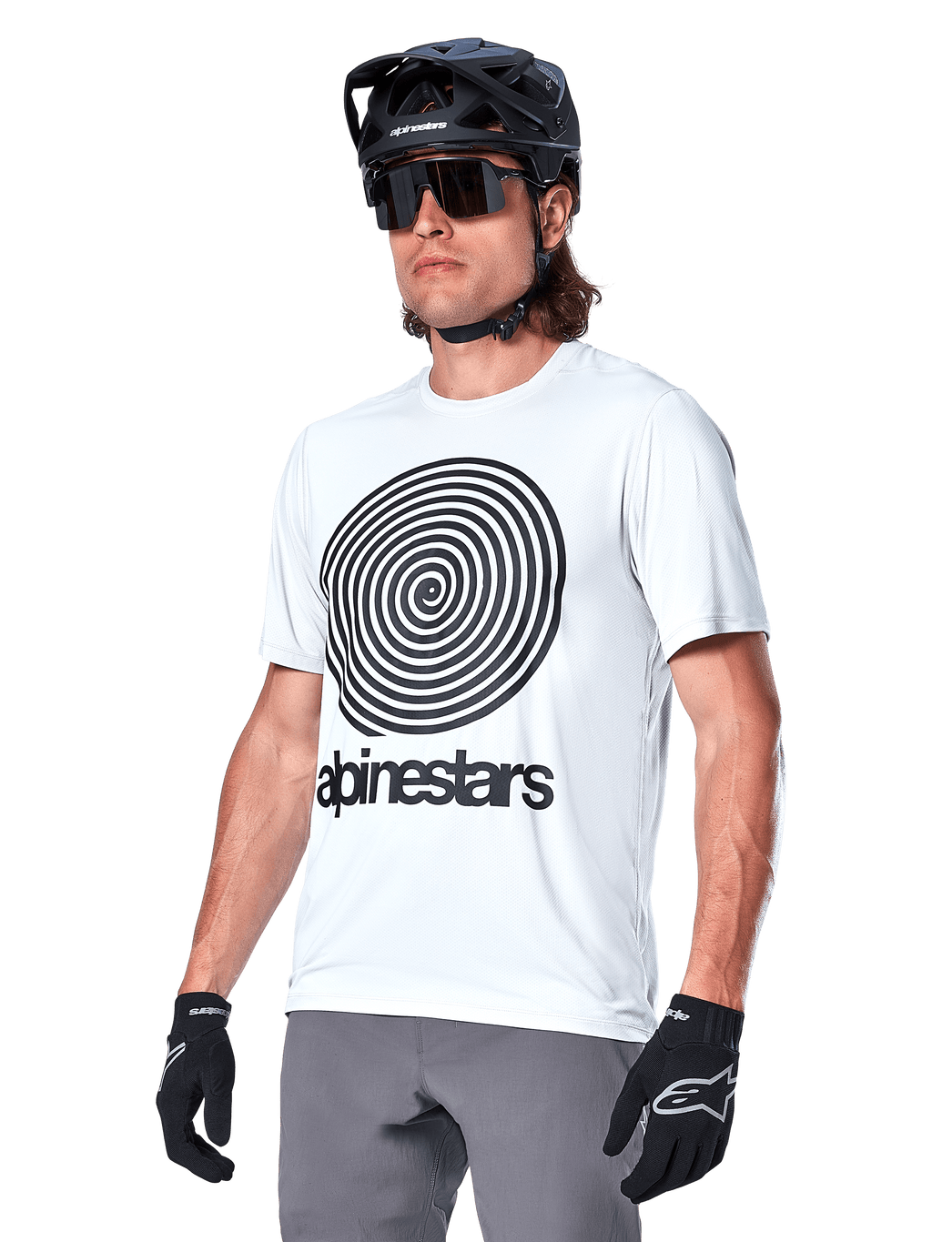 Alpinestars A-Dura Oscar Jersey a maniche corte, White Dove con grafica a spirale heritage e logo neri, indossata con casco da MTB e guanti neri, abbigliamento sportivo ad alte prestazioni per mountain bike
