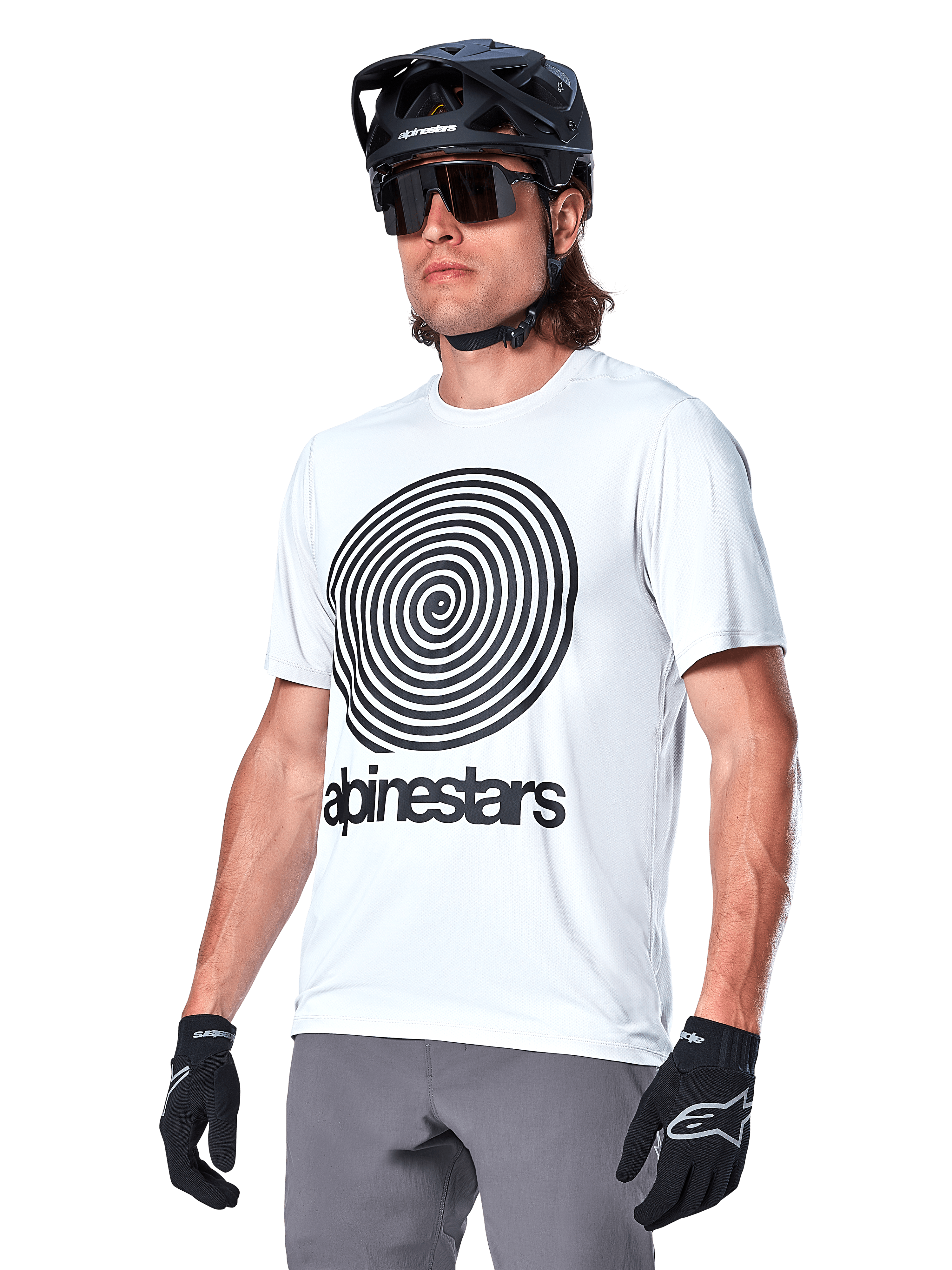 Alpinestars A-Dura Oscar Jersey a maniche corte, White Dove con grafica a spirale heritage e logo neri, indossata con casco da MTB e guanti neri, abbigliamento sportivo ad alte prestazioni per mountain bike
