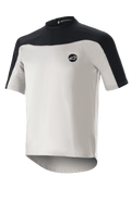 Alpinestars Drop Meta Jersey a maniche corte, maglia da mountain bike, grigio chiaro e nero, con struttura in rete traspirante, inserto nero sulle spalle, girocollo e parte posteriore allungata per una maggiore copertura.