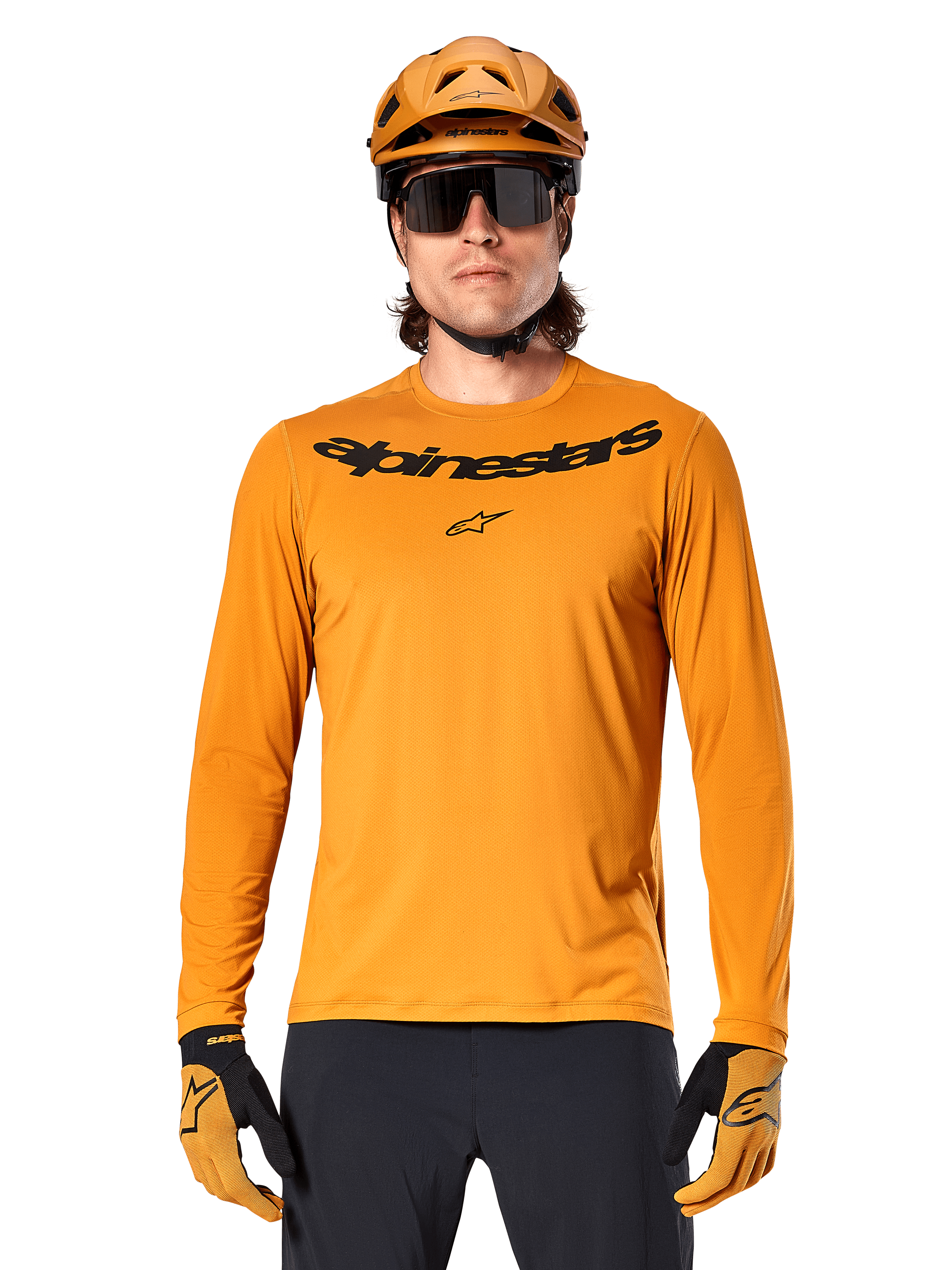 Maglia Alpinestars A-Dura Rocker a maniche lunghe in Dark Gold, con logo wordmark nero sul petto, indossata con casco e guanti coordinati color oro per prestazioni in mountain bike.