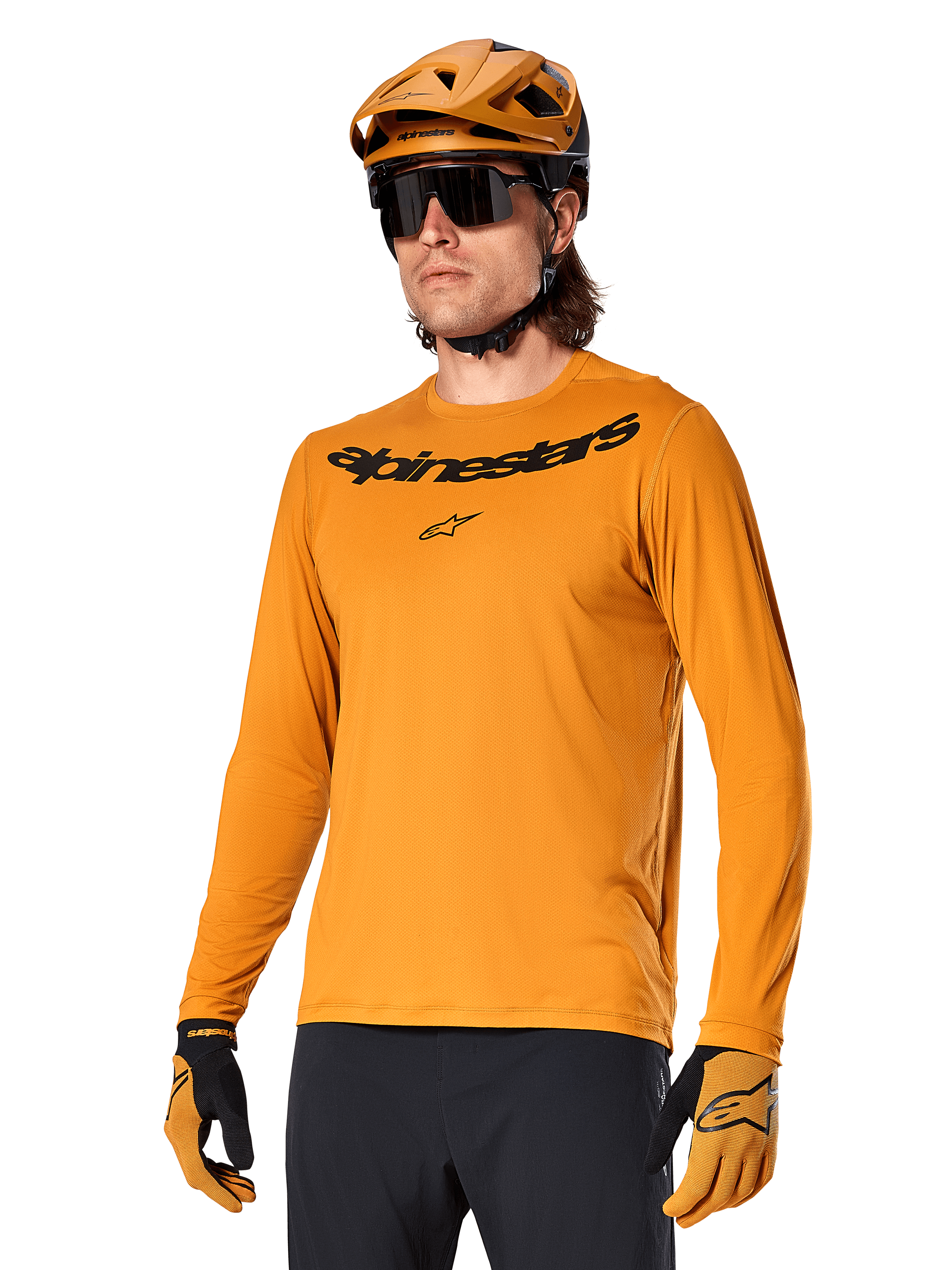 Alpinestars A-Dura Rocker Jersey a maniche lunghe, maglia da mountain bike MTB, Dark Gold, persona che indossa la maglia con casco e guanti coordinati, look sportivo coordinato con marchio Alpinestars sul petto