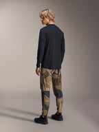 Alpinestars A-Dura Astar Long Sleeve Jersey, maglia MTB a maniche lunghe, nero, vista posteriore su modello, abbinata a pantaloni mimetici, abbigliamento tecnico casual con orlo posteriore allungato e vestibilità regolare
