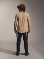 Maglia a maniche lunghe Alpinestars A-Dura Astar, marrone chiaro, vista posteriore che mostra la coda più lunga, indossata con pantaloni neri con marchio Alpinestars, abbigliamento tecnico da mountain bike