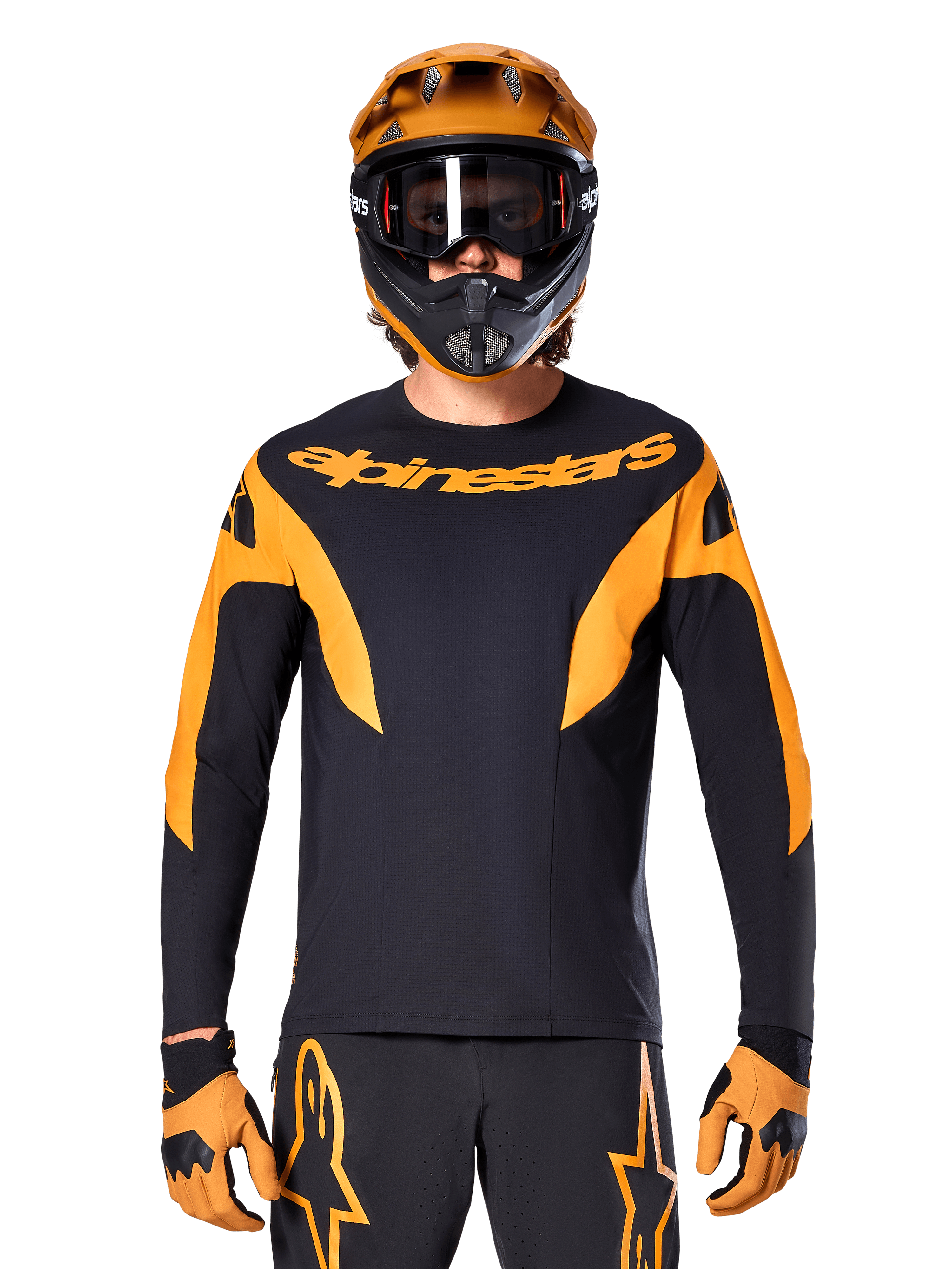 Rider MTB con maglia Alpinestars A-Supra Race - Maniche Lunghe, nera con grafiche arancioni e logo sul petto, indossata con casco integrale arancione coordinato, maschera nera e guanti arancioni, kit da gara coordinato per performance in mountain bike