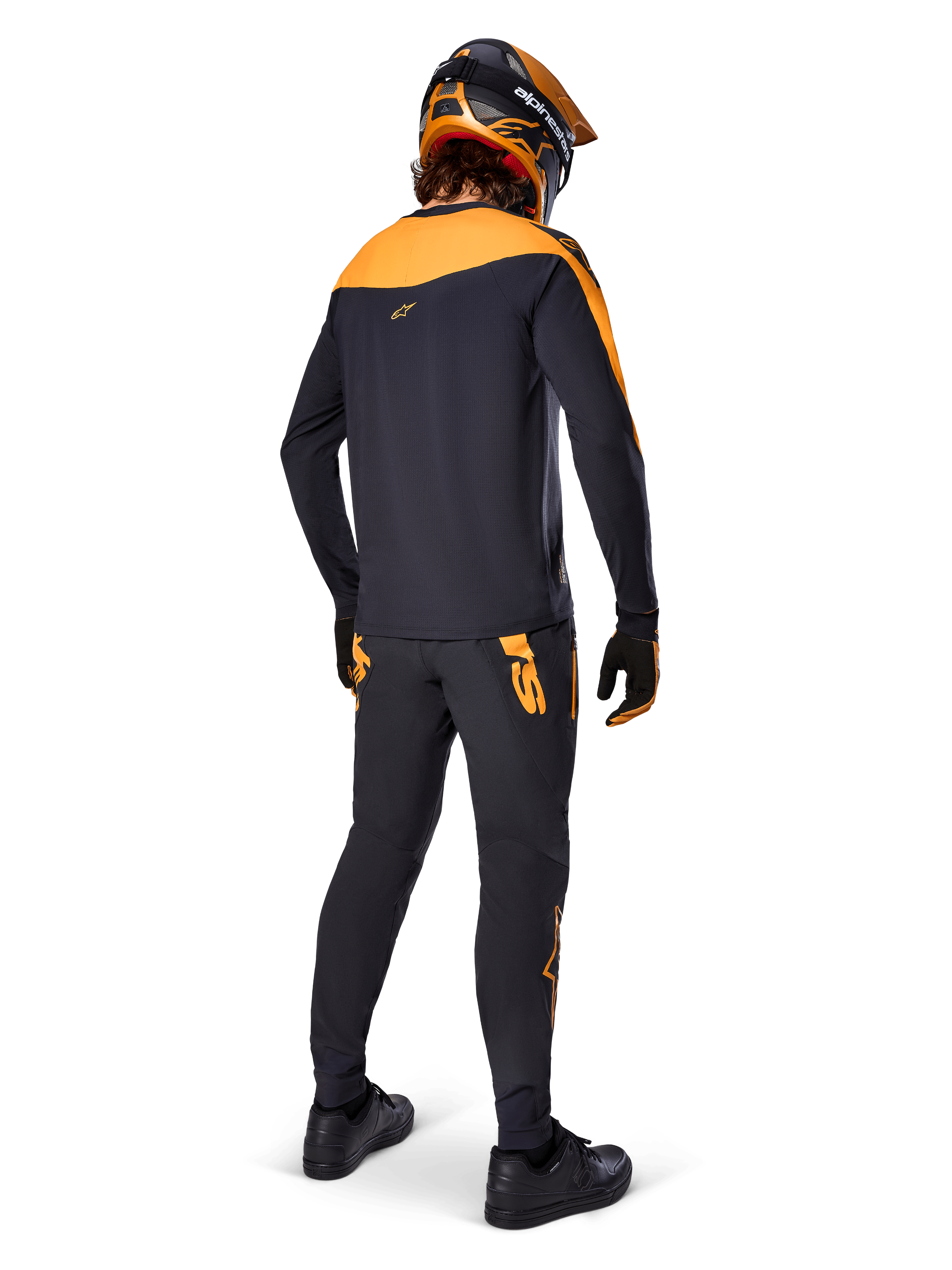 Alpinestars A-Supra Race Jersey - Maniche Lunghe, nero e arancione, vista posteriore di un rider che indossa pantaloni MTB coordinati, casco e guanti arancione e nero, abbigliamento tecnico per gare di mountain bike