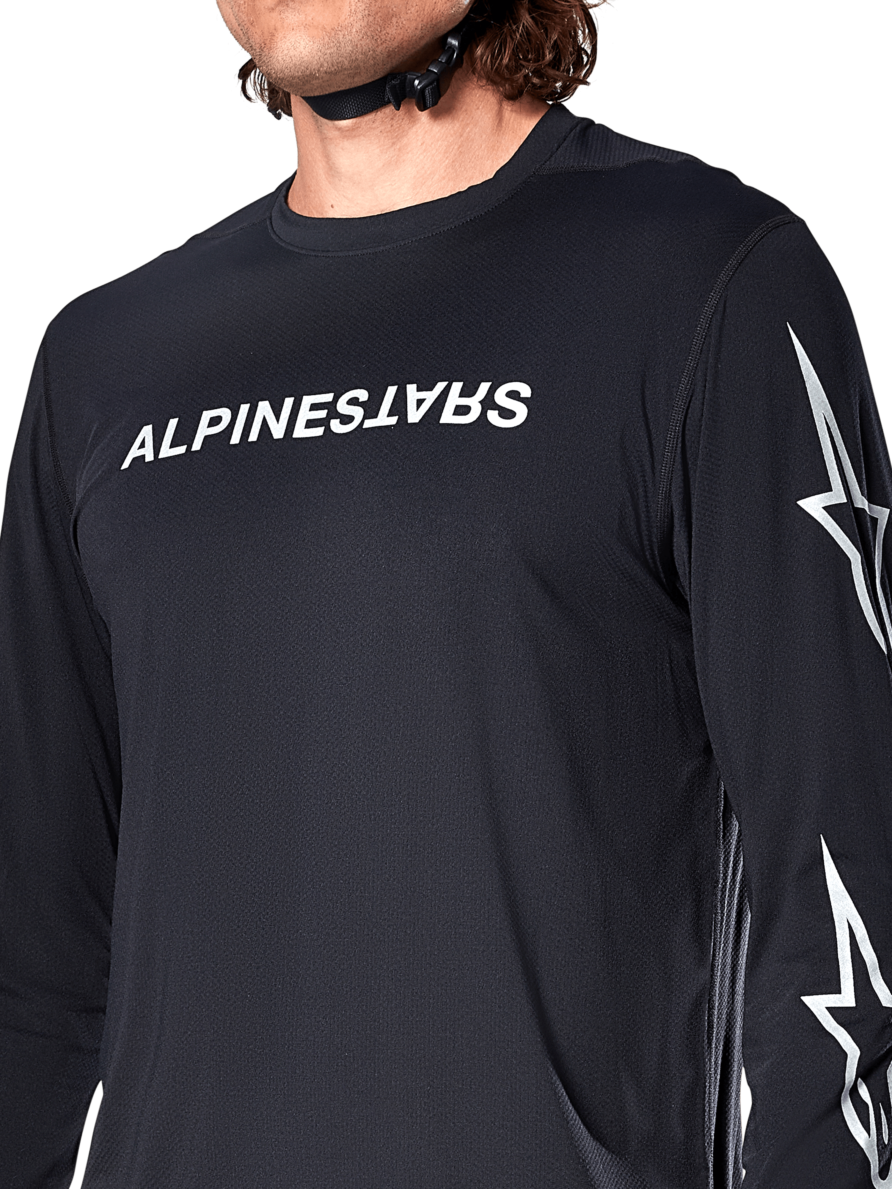Maglia Alpinestars A-Dura Switch Long Sleeve, nero, con scritta Alpinestars bianca sul petto e loghi a stella sulla manica, indossata da un rider con cinturino del casco visibile, abbigliamento tecnico da mountain bike.