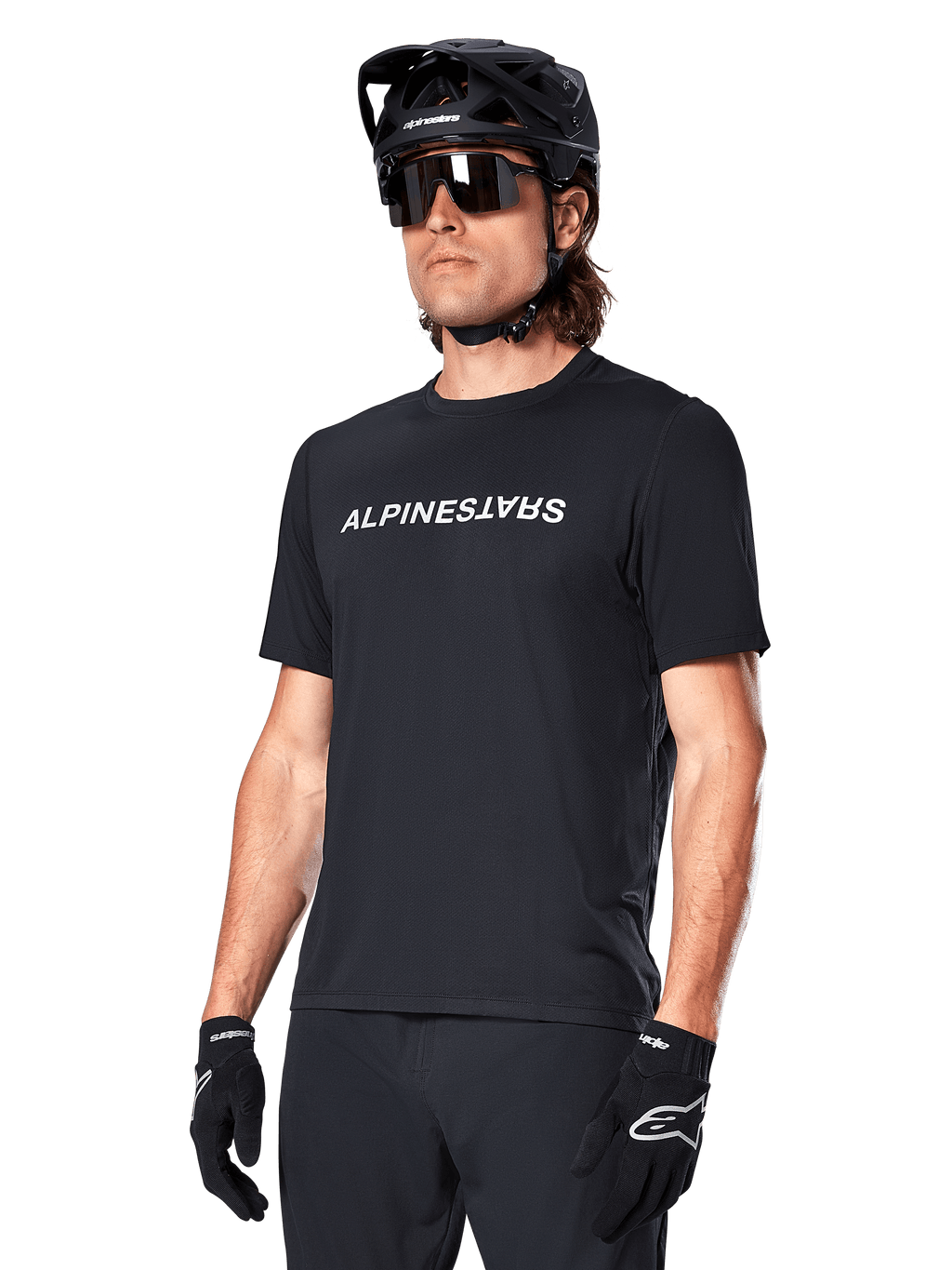 Alpinestars A-Dura Switch Short Sleeve Jersey, maglia a maniche corte, nero, con logo wordmark bianco sul petto, indossata da un ciclista con casco MTB nero e occhiali da sole, abbigliamento tecnico per trail riding