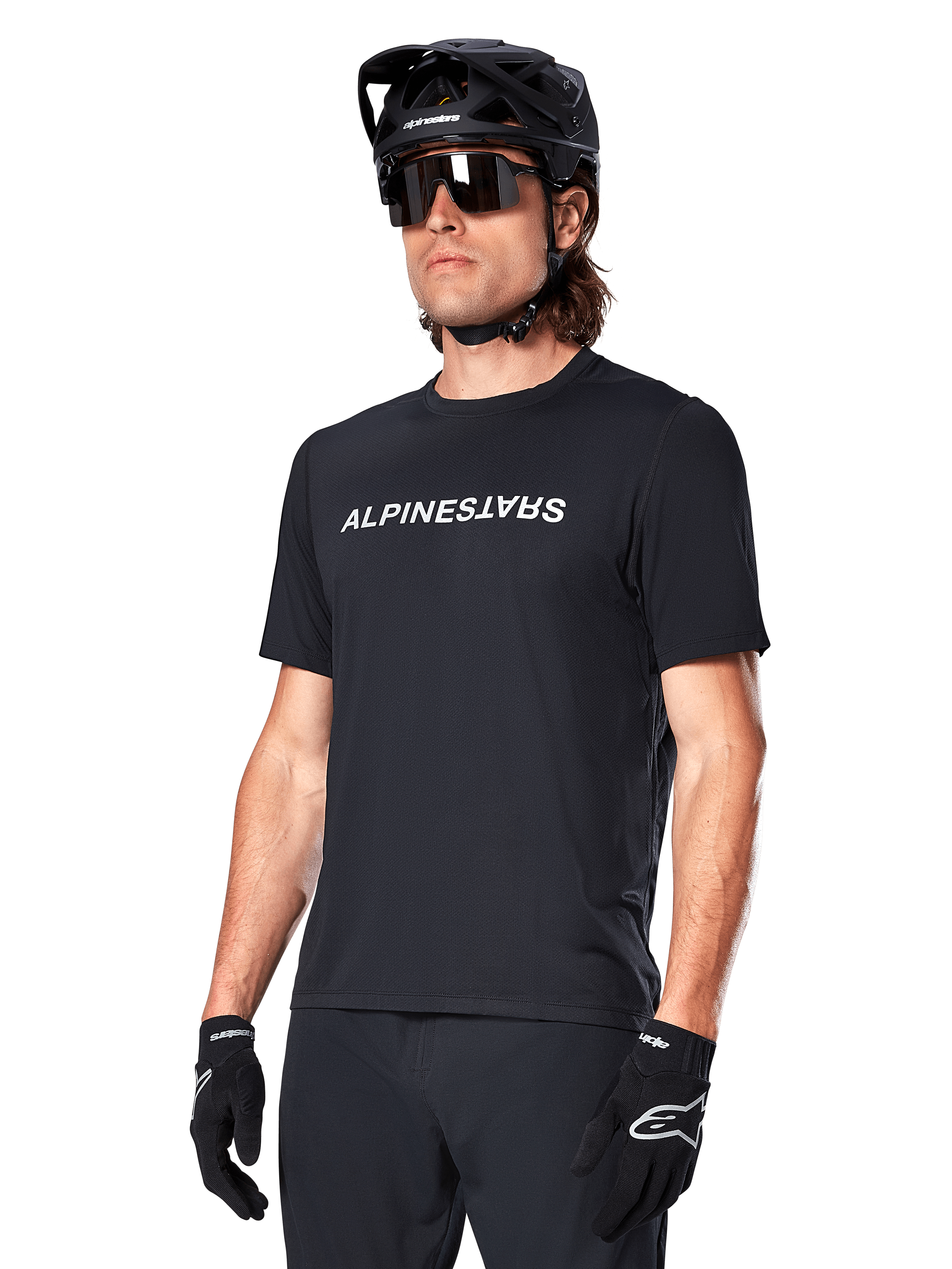 Alpinestars A-Dura Switch Short Sleeve Jersey, maglia a maniche corte, nero, con logo wordmark bianco sul petto, indossata da un ciclista con casco MTB nero e occhiali da sole, abbigliamento tecnico per trail riding