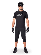 Alpinestars A-Dura Dri Oscar Short Sleeve Jersey, nero riflettente, indossata con pantaloncini da MTB neri coordinati, guanti, ginocchiere e casco, con un grande logo Alpinestars bianco sul petto, abbigliamento completo da mountain bike