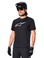 Alpinestars A-Dura Dri Oscar Jersey, maglia da ciclismo MTB a maniche corte, nera con logo bianco, tessuto tecnico traspirante, indossata con casco nero, occhiali da sole e guanti