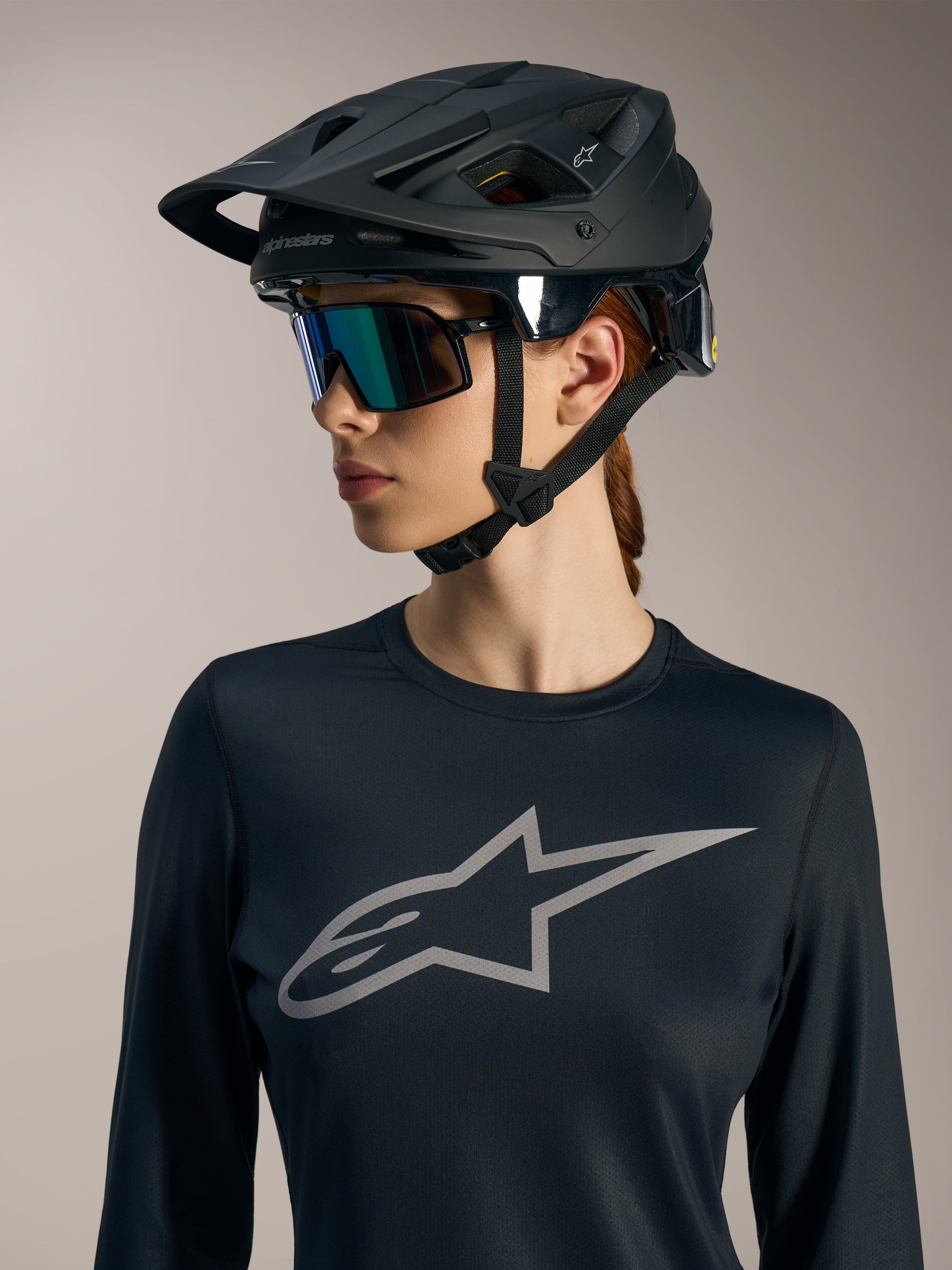Maglia Stella A-Dura Ride LS nera da donna, logo Astars grigio, indossata con casco da MTB nero opaco.