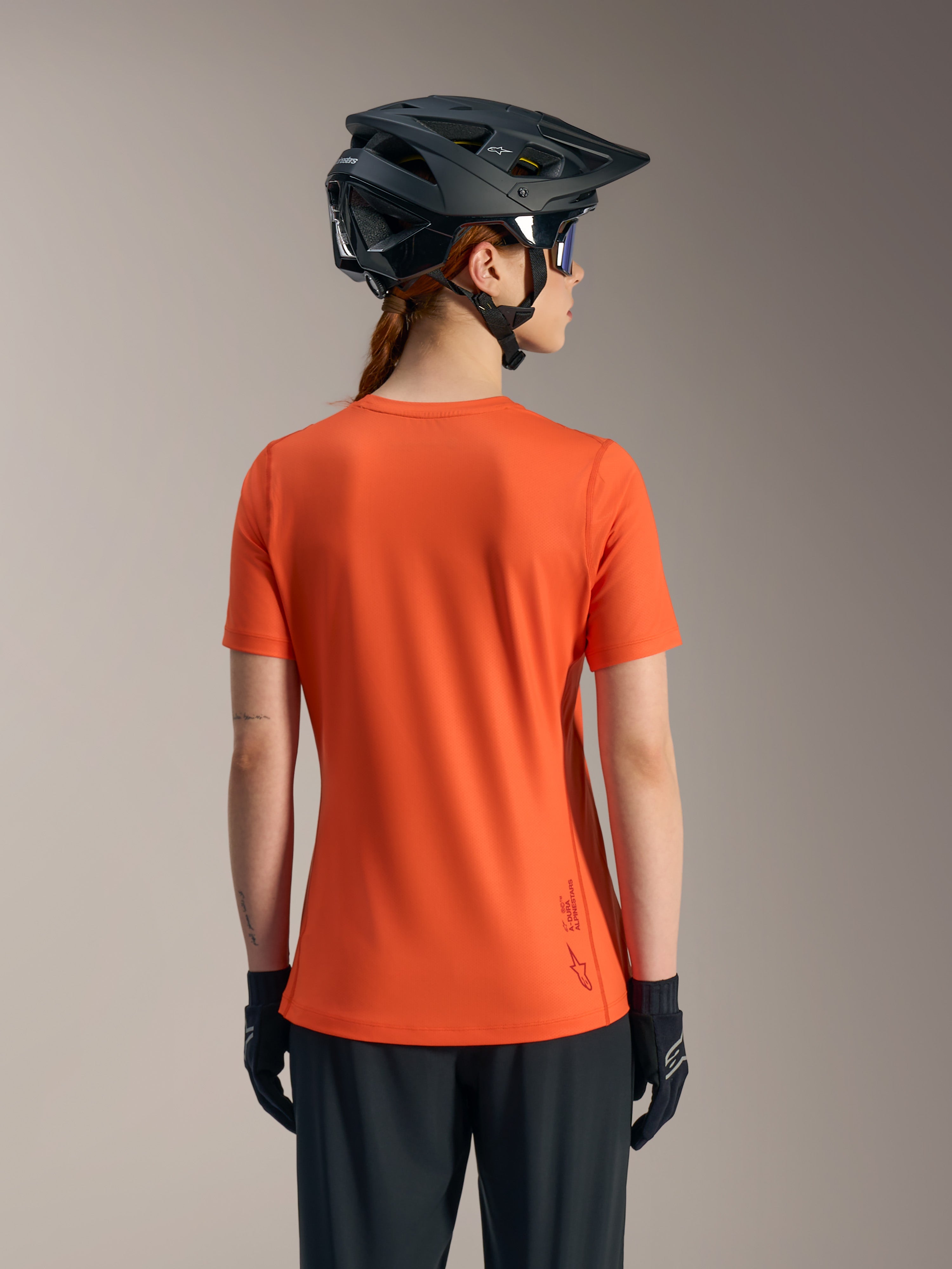 Maglia MTB Stella A-Dura Ride arancione, vista posteriore top donna a maniche corte in tessuto tecnico riciclato.