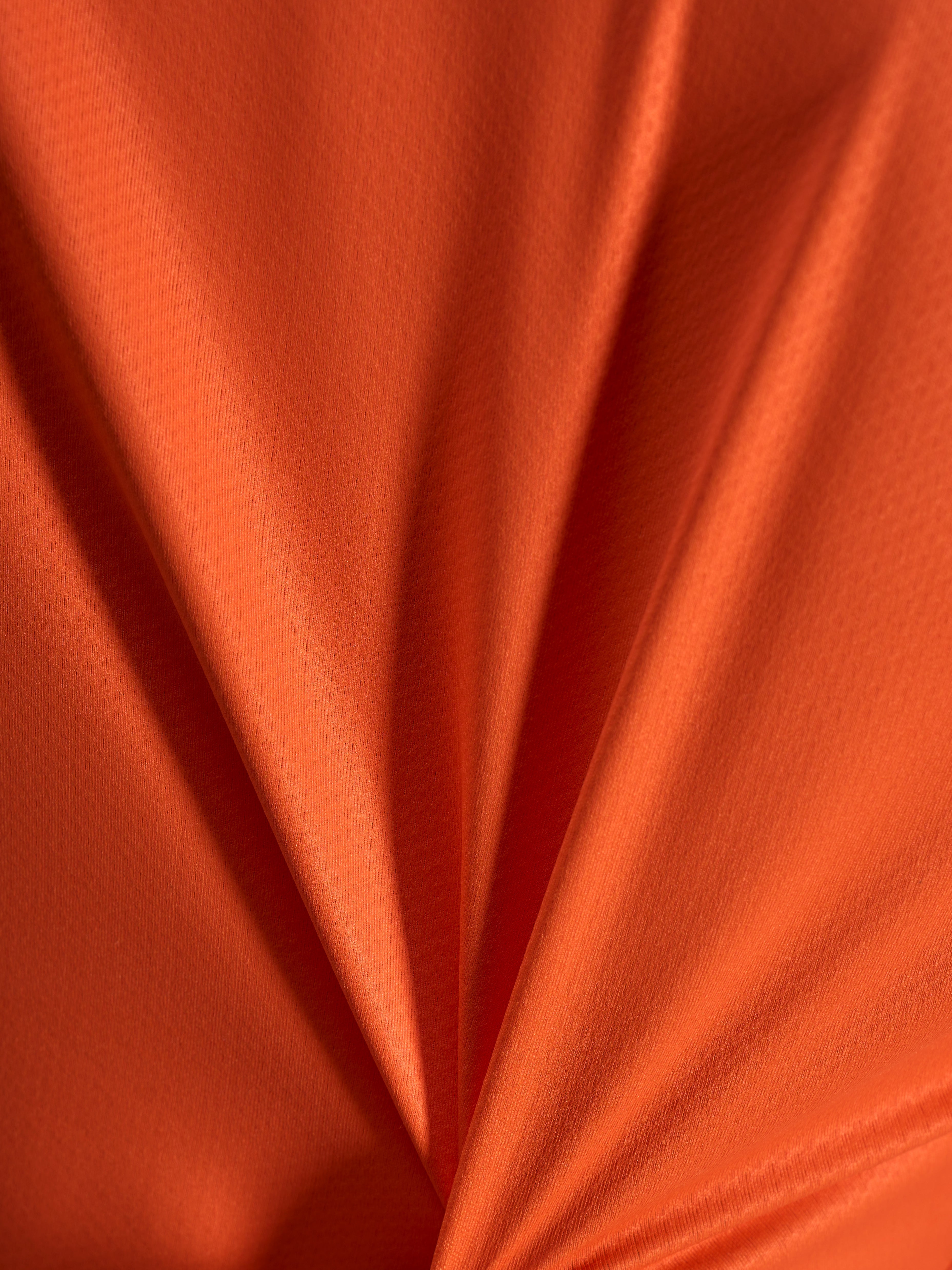 Dettaglio del tessuto jacquard arancione della maglia Alpinestars Stella A-Dura Ride, trama leggera ed elastica.