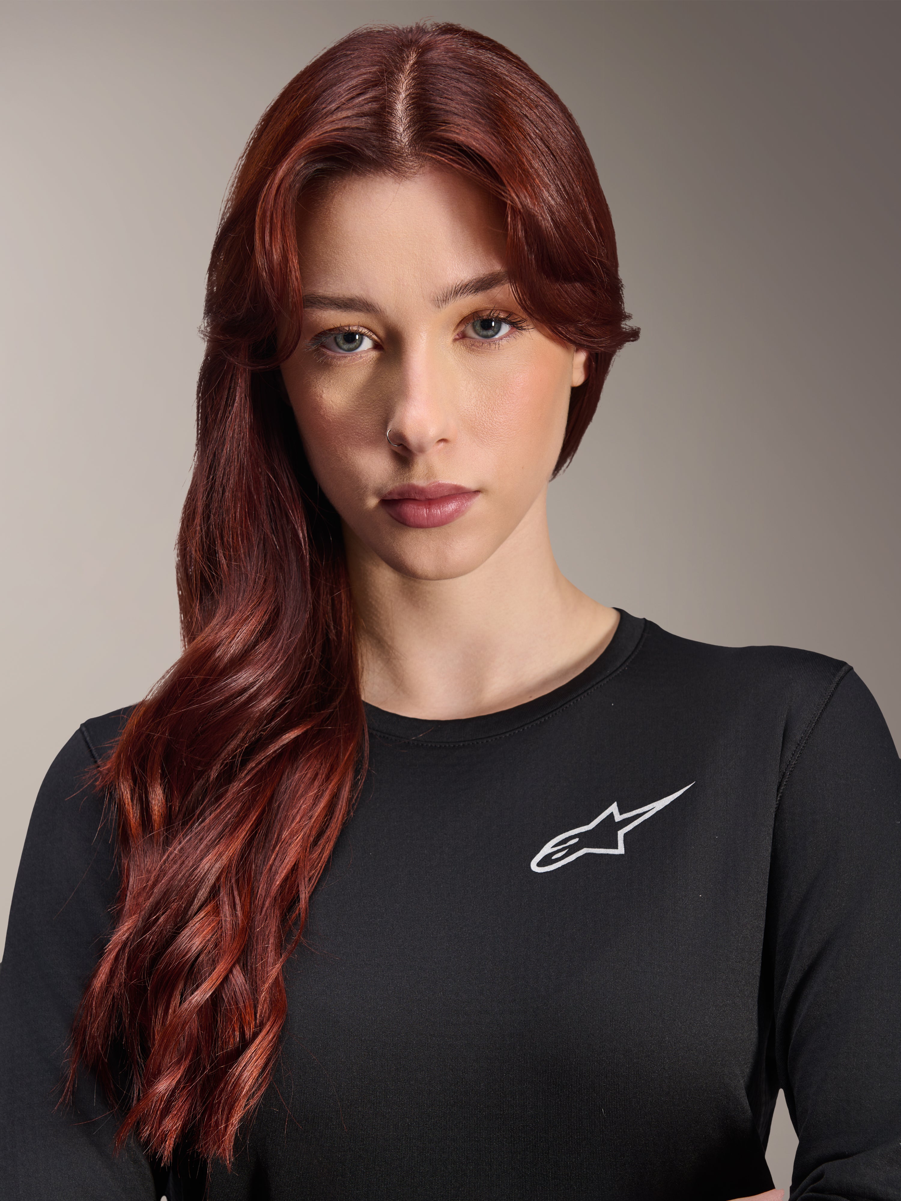 Alpinestars Stella A-Dura Thermal Jersey, maglia da MTB a maniche lunghe da donna, nero con logo A-star bianco sul petto, ritratto in primo piano di una donna con lunghi capelli rossi, abbigliamento da ciclismo per climi freschi