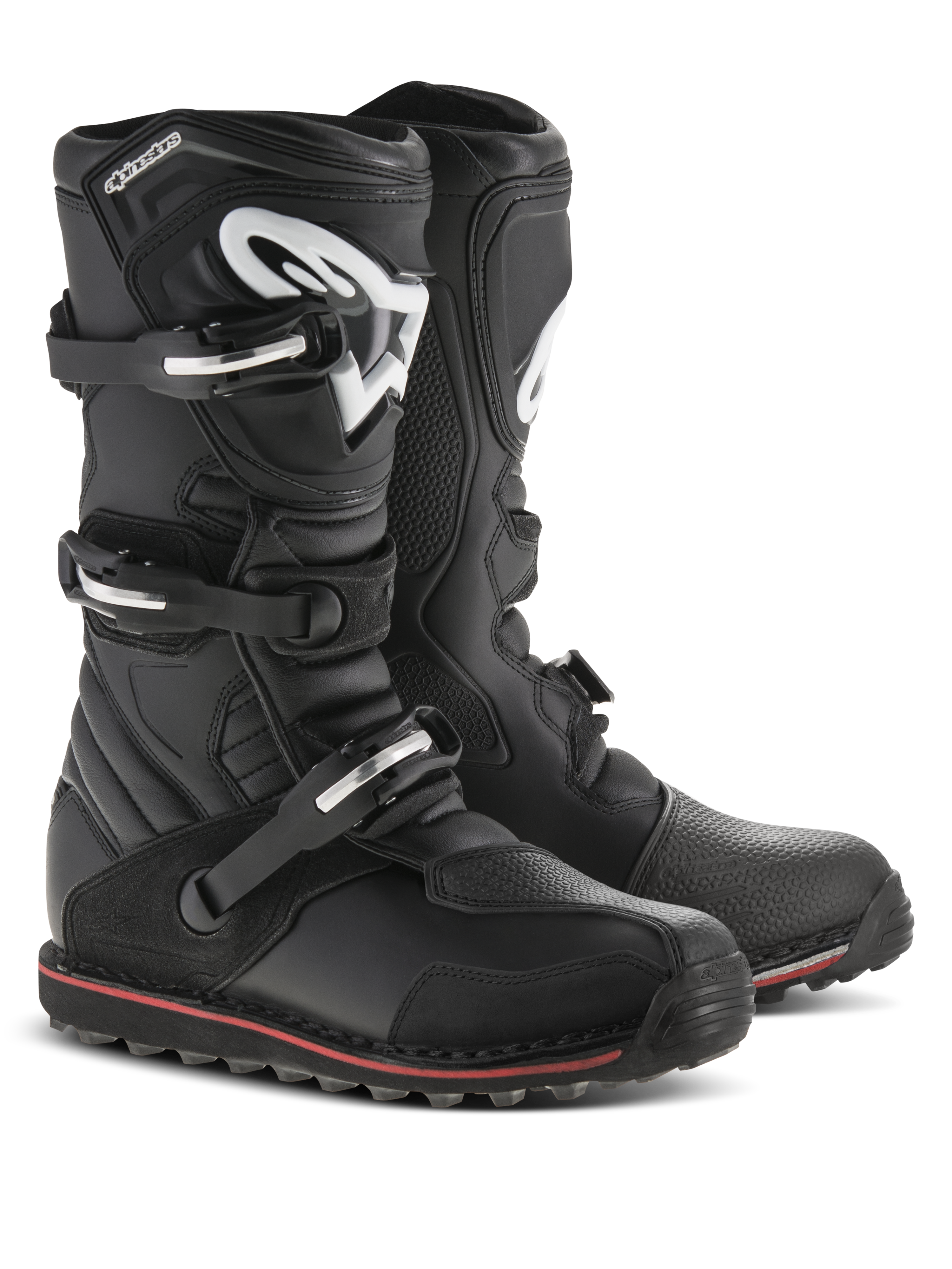 Alpinestars Tech-T Boots, stivali da moto da trial, nero con accenti rossi e bianchi, sistema di chiusura a tre fibbie, placca tibiale ergonomica con logo Astars bianco, sottile striscia rossa lungo la suola, robusta struttura in pelle per il trial e la guida fuoristrada