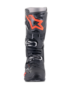 Stivali Alpinestars Tech 10, stivali da motocross, nero e rosso fluo, vista frontale, con un grande logo a stella rosso fluorescente sulla placca parastinchi, fibbie argentate e una resistente struttura in TPU nero.