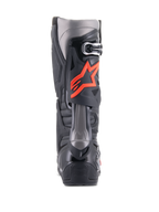 Alpinestars Tech 10 Boots, stivali da motocross, nero e rosso fluo, vista posteriore con calotta tecnica in TPU, pannelli grigio scuro e vistoso logo a stella rosso fluorescente sul polpaccio.
