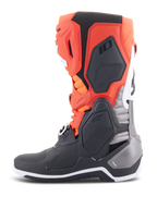 Stivali Alpinestars Tech 10, stivali da motocross, nero, rosso fluo e arancione fluo con accenti bianchi, vista laterale che mostra l'avanzato telaio in TPU, il sistema di fibbie e il design ergonomico per prestazioni fuoristrada