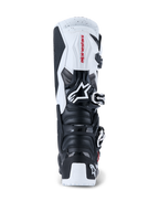 Alpinestars 2026 Tech 7 Enduro Boots, stivali da motocross ed enduro, nero e bianco, vista posteriore che mostra le piastre protettive in TPU su tallone e polpaccio, logo Alpinestars rosso su pannello superiore bianco e sistema di chiusura con fibbie argentate, progettati per il fuoristrada ad alte prestazioni.