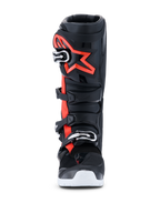 Alpinestars 2026 Tech 7 Enduro Drystar® Boots, stivali da motocross ed enduro, nero rosso fluo e bianco, vista frontale, con sistema di chiusura a quattro fibbie, placca tibiale in TPU rinforzato con un grande logo Alpinestars rosso e suola bianca, progettati per prestazioni off-road impermeabili.