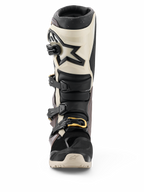 Stivali Alpinestars 2026 Tech 7 Enduro Drystar®, nero, grigio scuro e oro, stivali da moto fuoristrada impermeabili, vista frontale con sistema di chiusura a fibbie multiple con accenti dorati, protezione per lo stinco in TPU e design con logo a stella