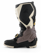 Alpinestars 2026 Tech 7 Enduro Drystar® Boots, stivali da motocross, nero, grigio scuro e oro, vista laterale che mette in risalto i resistenti pannelli in TPU, la fibbia con accenti dorati e la robusta suola enduro per la guida fuoristrada.