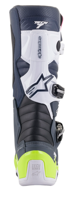 Stivali Alpinestars Tech 7, stivali da motocross, vista posteriore in blu scuro, bianco e grigio scuro con protezione del tallone giallo fluo, zone di flessione a fisarmonica e marchio Tech Series