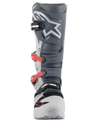 Stivali Alpinestars Tech 7 Enduro, stivali da motocross ed enduro, grigio chiaro, grigio scuro e rosso acceso, vista frontale con sistema di fibbie avanzato con cinturini rossi, placca tibiale in TPU grigio scuro con logo a stella bianco e struttura resistente in grigio chiaro.