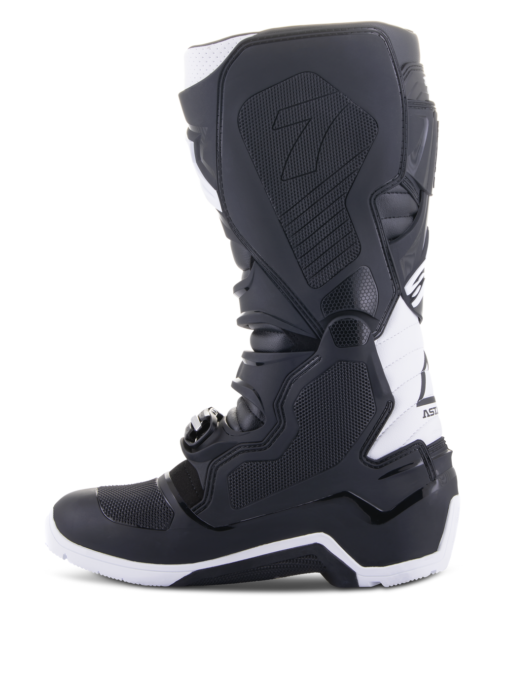 Stivali Alpinestars Tech 7 Enduro Drystar®, stivali da moto enduro, nero e bianco, vista laterale mediale con pannelli grip con trama a nido d'ape, costruzione in TPU e accenti bianchi sul tallone e sulla parte superiore del polpaccio, calzatura professionale da fuoristrada