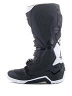 Stivali Alpinestars Tech 7 Enduro Drystar®, stivali da moto enduro, nero e bianco, vista laterale mediale con pannelli grip con trama a nido d'ape, costruzione in TPU e accenti bianchi sul tallone e sulla parte superiore del polpaccio, calzatura professionale da fuoristrada