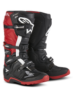 Stivali Alpinestars Honda Tech 7 Enduro Drystar®, stivali da moto per enduro, nero e rosso acceso, vista frontale a tre quarti con sistema di chiusura a quattro fibbie, placche parastinchi protettive e suole rosse ad alta aderenza con loghi Honda e Alpinestars.
