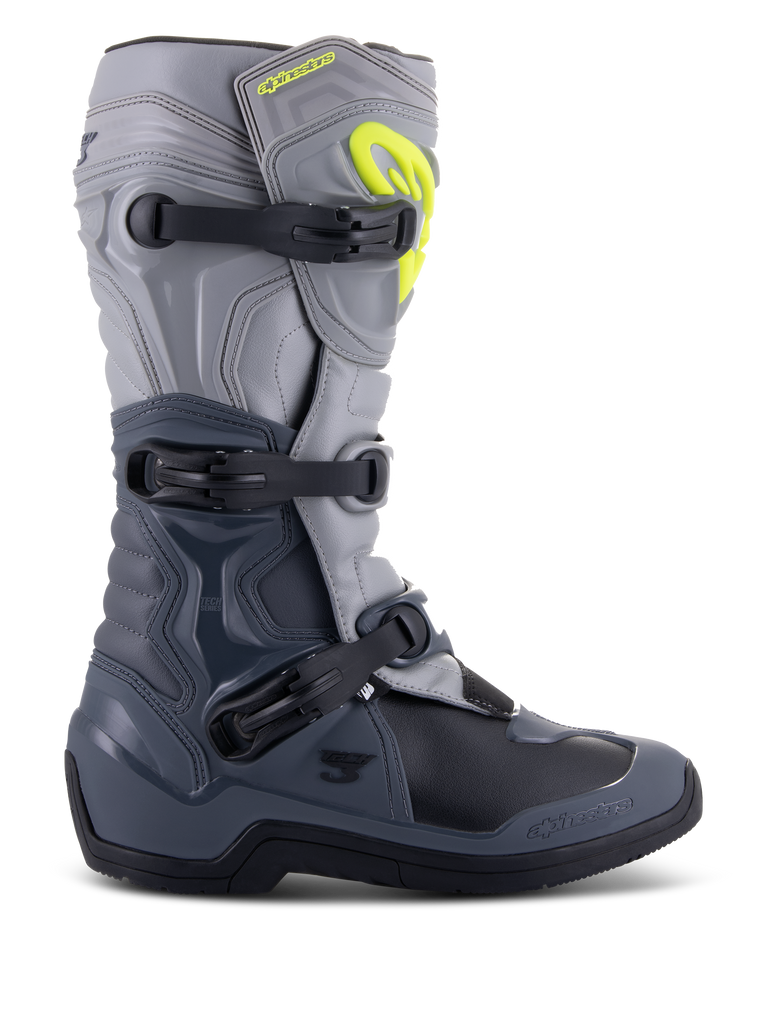 Stivali Alpinestars Tech 3, stivali da motocross, grigio scuro, grigio chiaro e nero, vista laterale con tre fibbie in polimero nero, pannelli di protezione in TPU e logo Alpinestars giallo brillante sulla parte superiore dello stinco