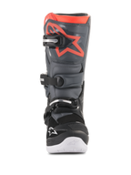 Stivali Alpinestars Youth Tech 7S, stivali da motocross, nero e grigio scuro con accenti rosso fluorescente, vista frontale, con placca tibiale in TPU e logo a stella rosso, sistema di chiusura a tre fibbie e suola integrata bianca, equipaggiamento protettivo resistente per fuoristrada