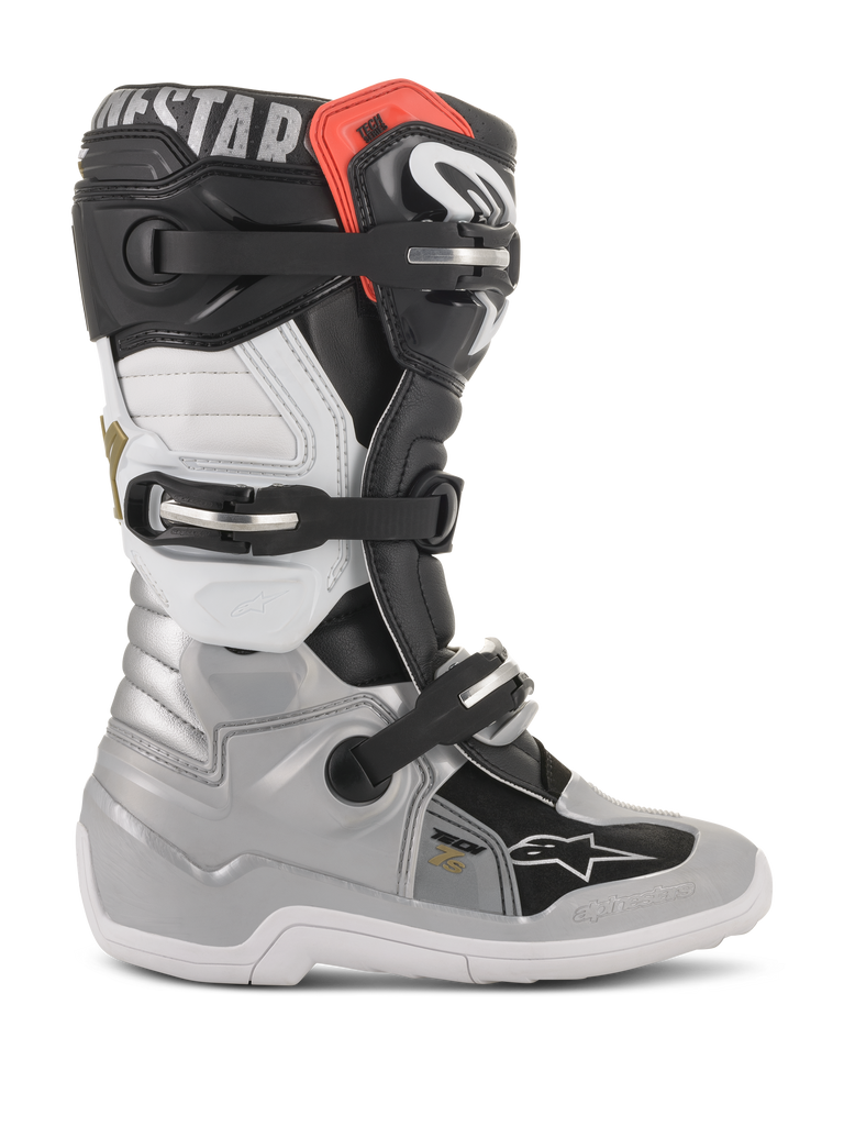 Stivali Alpinestars Youth Tech 7S, stivali da motocross, nero, argento, bianco e oro, profilo laterale con sistema di chiusura a fibbia, protezioni in TPU e costruzione resistente per giovani piloti