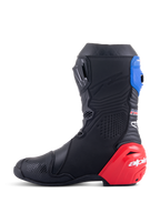Stivali Alpinestars Honda Supertech R, stivali da moto racing, nero con accenti rosso acceso e blu, con vistoso cursore del tallone in TPU rosso, ghetta superiore blu e loghi Alpinestars, design tecnico per prestazioni professionali su pista e strada