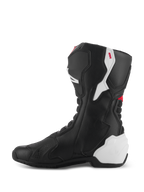 Stivali Alpinestars SMX-6 V3, stivali da moto performanti, grafica nero bianco rosso, vista laterale mediale, costruzione in microfibra nera con pannelli protettivi in TPU bianco su tallone e polpaccio, accenti rossi e zone a fisarmonica flessibili per una maggiore mobilità e protezione.
