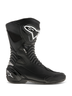 Alpinestars SMX S, stivali da moto racing, neri con loghi bianchi, vista laterale con struttura in microfibra durevole, protezioni rinforzate per stinco e tallone, zone flessibili a fisarmonica e design aerodinamico per la guida sportiva