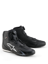 Scarpe Alpinestars Celer, scarpe da moto, nero e bianco, dotate di rotore Rotor Closure System, grande logo Astar bianco sul lato, elegante struttura in microfibra tecnica per prestazioni sportive su strada