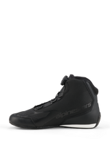 Scarpe Alpinestars Celer, scarpe da moto, nero e bianco, profilo laterale con sistema di chiusura Rotor, costruzione in microfibra con logo in rilievo e contrasto bianco sul tallone.