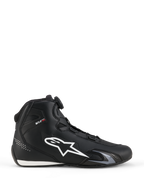 Scarpe Alpinestars Celer, scarpe da moto, nero e bianco, profilo laterale con grande logo a stella bianco, sistema di chiusura a rotore per la regolazione della calzata e silhouette sportiva ad alte prestazioni