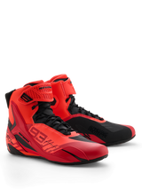 Scarpe Alpinestars MM93 Faster-4, scarpe da moto, rosso fluo, rosso brillante e nero, prospettiva anteriore destra, con marchio Marc Marquez 93, chiusura tradizionale con lacci e cinturino a strappo, design sportivo con inserti protettivi in TPU e struttura in microfibra leggera.