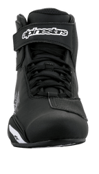 Scarpe Alpinestars Sektor, scarpe da moto, nero e bianco, vista frontale con sistema di allacciatura rapida e cinturino alla caviglia a strappo con logo bianco, elegante struttura in microfibra per la guida su strada