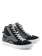 Alpinestars Stated Shoes, scarpe da moto, nero, grigio e bianco, design high-top d'ispirazione skate rétro con lacci bianchi e suola in gomma vulcanizzata, logo Alpinestars sul lato e un mix di materiali in scamosciato e tela.