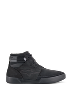 Alpinestars Primer Riding Shoes, sneaker da moto nere, calzature da guida urbana alte, vista laterale, tomaia in mesh testurizzato, suola in gomma spessa, design sportivo moderno con logo a stella discreto
